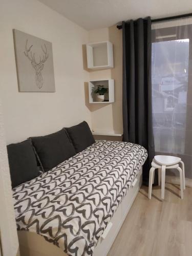 a bedroom with a bed with a black and white comforter at Appartement au pied des pistes Risoul in Risoul