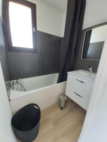 a bathroom with a tub and a sink and a mirror at Appartement au pied des pistes Risoul in Risoul
