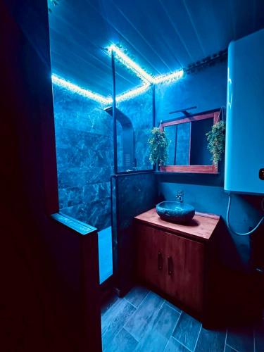 a blue bathroom with a sink and a mirror at Oasis Tropical Sauna Privé Vue Mer & Plage À 100M in Saint-Hilaire-de-Riez