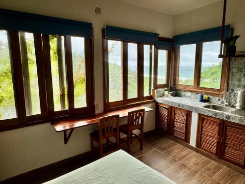 a kitchen with windows and a counter with a sink at Estudio con vista al mar, AC, WIFI Starlink, Parking in San Agustinillo