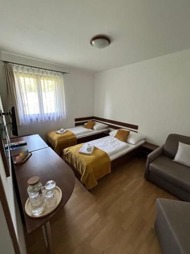 a hotel room with two beds and a couch at Resort Levočská Dolina in Levoča
