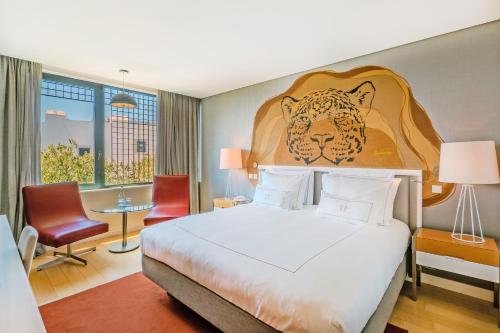a hotel room with a bed with a tiger head on the wall at Pestana Cidadela Cascais - Pousada & Art District in Cascais