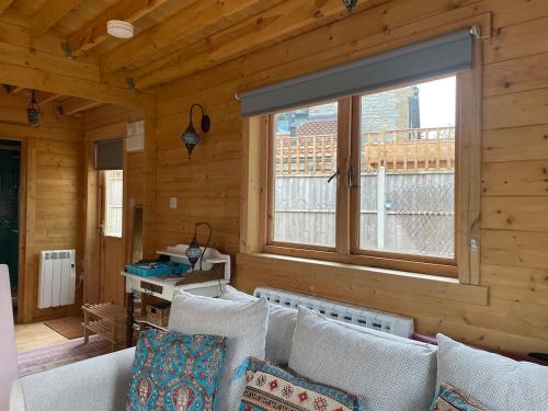 a living room with a couch and a window at The Cabin at Box Cottage in Somerton