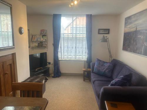 a living room with a couch and a window at Flat G, 8 Castle Street in Ludlow