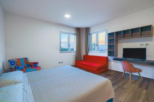Un dormitorio con una cama, un sofá y un televisor. en Villa Opulentia piscine vista mare, en Plemmirio