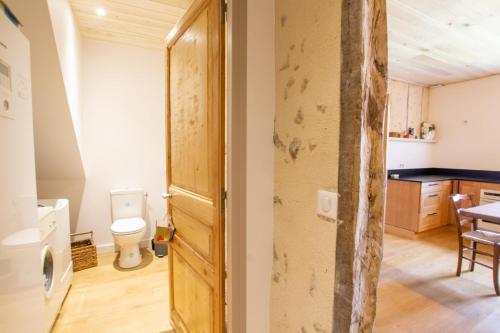 a bathroom with a toilet and a kitchen at Gite du puits in Saint-Estèphe