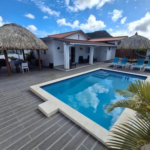 a swimming pool in front of a house at Caribbean Breeze-4 bedroom 4 ensuite bathrooms in Oranjestad