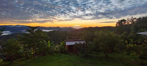 a house on a hill with the sunset in the background at Mountain view 