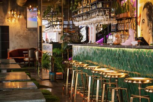 a bar with gold stools and a green counter at Lisbon Art Stay Hotel & Apartments in Lisbon
