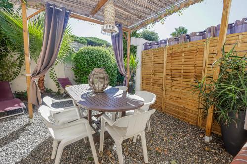 a patio with a table and chairs and a fence at Rêve D'azur plage de la Nartelle, maison Julia avec Piscine partagée, Parking & Terrasse BBQ, Wifi et Draps Inclus in Sainte-Maxime