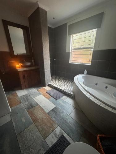 ein großes Badezimmer mit Badewanne und Fenster in der Unterkunft At Harmony in Germiston