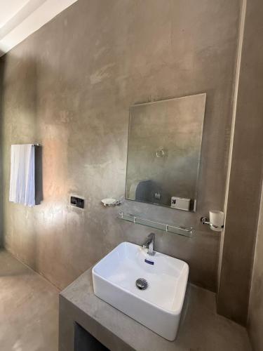 a bathroom with a white sink and a mirror at The Green Loft Rooms in Ahangama