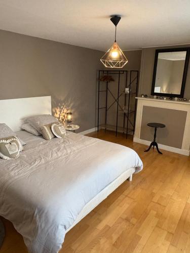 a bedroom with a large white bed and a fireplace at Appartement centre ville in Langres
