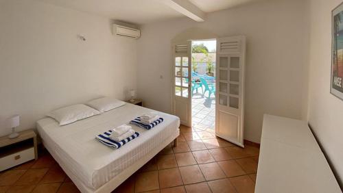 Un dormitorio con una cama con toallas. en Ti Paradi, villa 12 pers, 2 piscines, vue golf mer, en Les Trois-Îlets