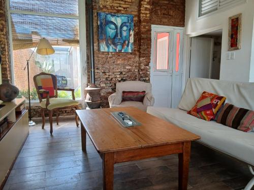 a living room with a couch and a coffee table at La Casa de Alvear - Casco Histórico in San Antonio de Areco