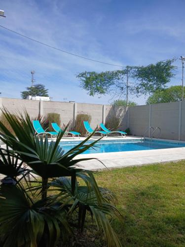 a swimming pool with blue chairs in a yard at La Casa de Alvear - Casco Histórico in San Antonio de Areco