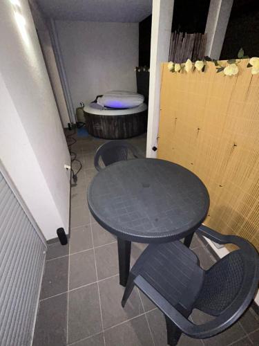 - une table et des chaises dans une chambre avec toilettes dans l'établissement CocoonJacuzzi, à Marseille