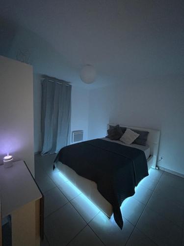 une chambre avec un lit éclairé à la lumière bleue dans l'établissement CocoonJacuzzi, à Marseille