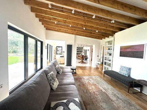 a living room with a gray couch and a large window at 6BR Designer Home OR SEPARATE 2BR Guesthouse OPTION in Fethard on Sea