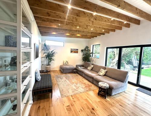a living room with a couch and a table at 6BR Designer Home OR SEPARATE 2BR Guesthouse OPTION in Fethard on Sea