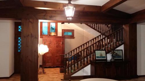 a hallway with a wooden staircase in a house at Pompei Rooms and Apartment in Pompei