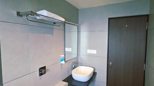 a bathroom with a toilet and a glass door at Hotel The Golden Oaks, Kolhapur in Kolhapur