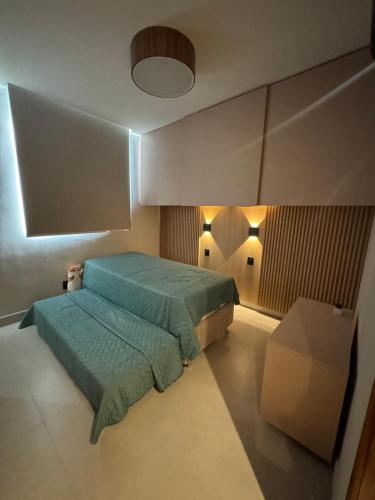 a bedroom with a green bed and a table at Refúgio da Lagoa azul in Angra dos Reis
