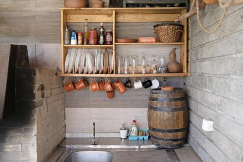 a kitchen with a sink and a barrel on a wall at Casa de Férias Garrett in Lagoa