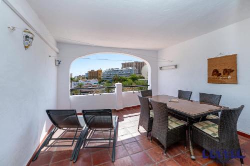 een eetkamer met een tafel en stoelen en een raam bij 2 BR Beach and Pool By Better Bookings in Arroyo de la Miel