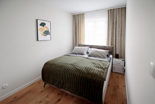 a bedroom with a bed and a window at Apartamenty EUROPA in Jasło