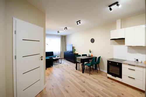 a kitchen and living room with a table and chairs at Apartamenty EUROPA in Jasło