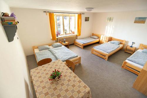 a room with three beds and a table and chairs at Chalupa u Hejsků in Jilem
