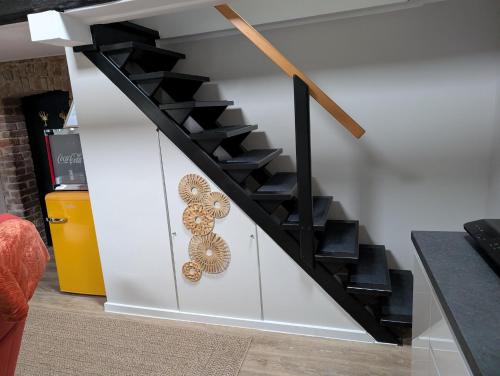 a staircase with black treads and a wall with a painting at Hühnerstall nahe Düsseldorf in Erkrath