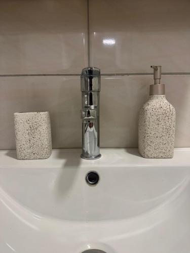 a bathroom sink with a bottle of soap on it at Aparte - Emshir in Prishtinë