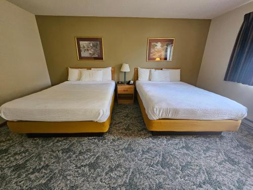 a hotel room with two beds in a room at Budget Host Inn & Suites in Escanaba