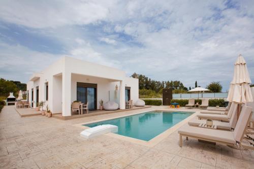 a villa with a swimming pool and patio furniture at Peratzada in Tsilivi