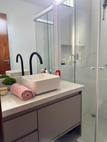 a bathroom with a white sink and a shower at Refúgio da Lagoa azul in Angra dos Reis