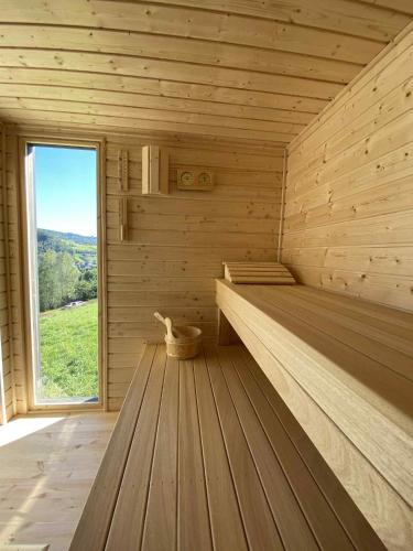 a sauna with wooden floors and a large window at elements - Solina, z sauną in Solina
