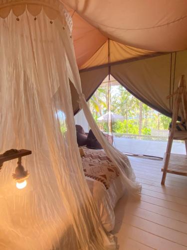 a bedroom with a bed in a tent at Romantic Eco safary tent,Cozy by Natura,private pool,sea view, Exotic luxury private glamping in Nusa Penida