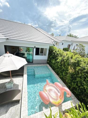 a swimming pool with a pool noodle in front of a house at Aonang nine poolvilla resort in Ao Nang