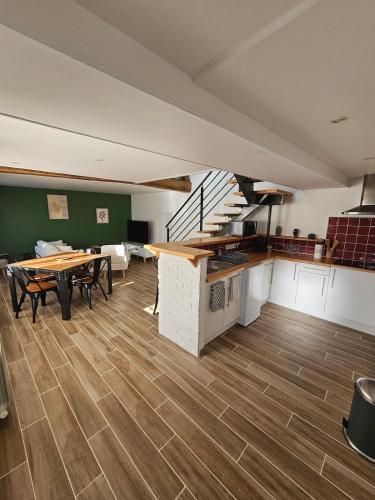 una grande stanza con un tavolo e una scala di La P'tite Maison a Saint-Julien-sur-Cher