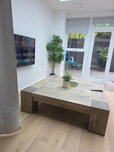 a wooden bench in a room with a table at Bee Hive Studio Flat in Manchester
