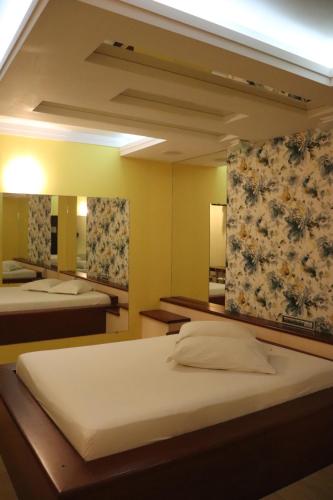 a bedroom with two beds and two mirrors at Motel Chevalier - Athos Hospedagem in Lages