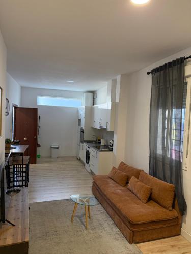 a living room with a brown couch and a kitchen at Bouzasol in Vigo