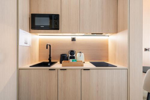 a small kitchen with a sink and a microwave at Dobo Madrid Ricardos in Madrid
