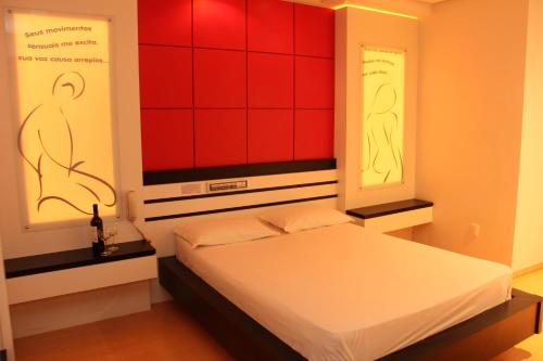 a bedroom with a bed with red and red walls at Motel Chevalier - Athos Hospedagem in Lages