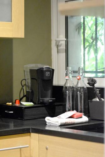 eine Küchentheke mit Kaffeemaschine und Flaschen darauf in der Unterkunft Chez Léonore in Chartres