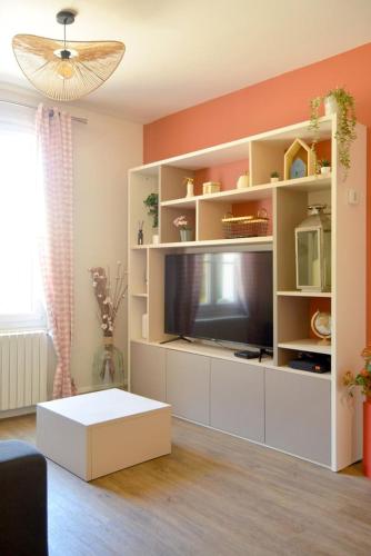 ein Wohnzimmer mit einem großen Entertainment-Center mit Fernseher in der Unterkunft Chez Léonore in Chartres