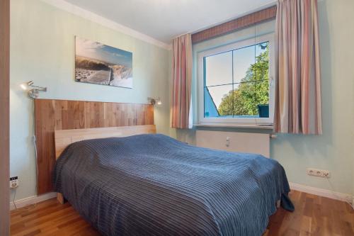 ein Schlafzimmer mit einem Bett und einem Fenster in der Unterkunft Ferienwohnung am Gespensterwald in Nienhagen