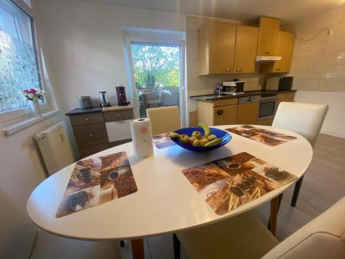 a kitchen with a table with a bowl of fruit on it at Moderne 3 Zimmer Wohnung mit 2 Badezimmer in Herbolzheim! in Herbolzheim